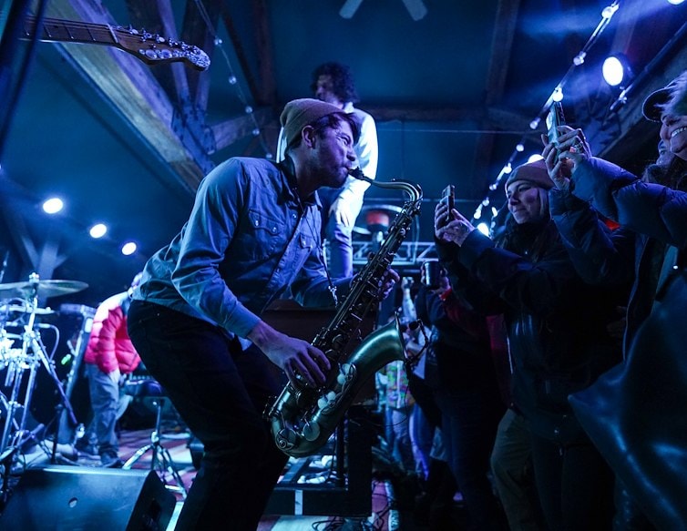 andy frasco and a saxaphone playing in front of a crowd at apres only