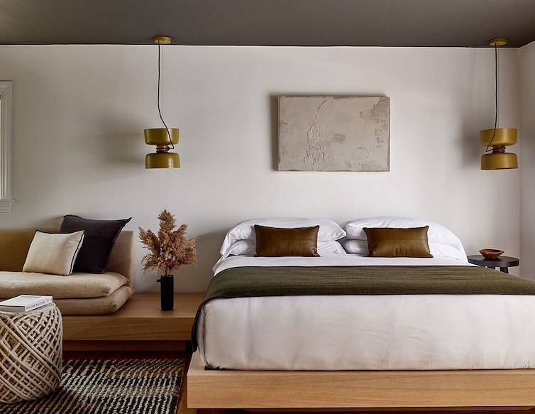 cozy bedroom featuring a white bed on a wooden floor, creating a warm and inviting atmosphere.