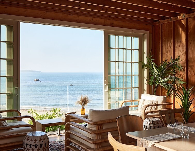 Elegant dining area overlooking the ocean, with tables arranged near the windows