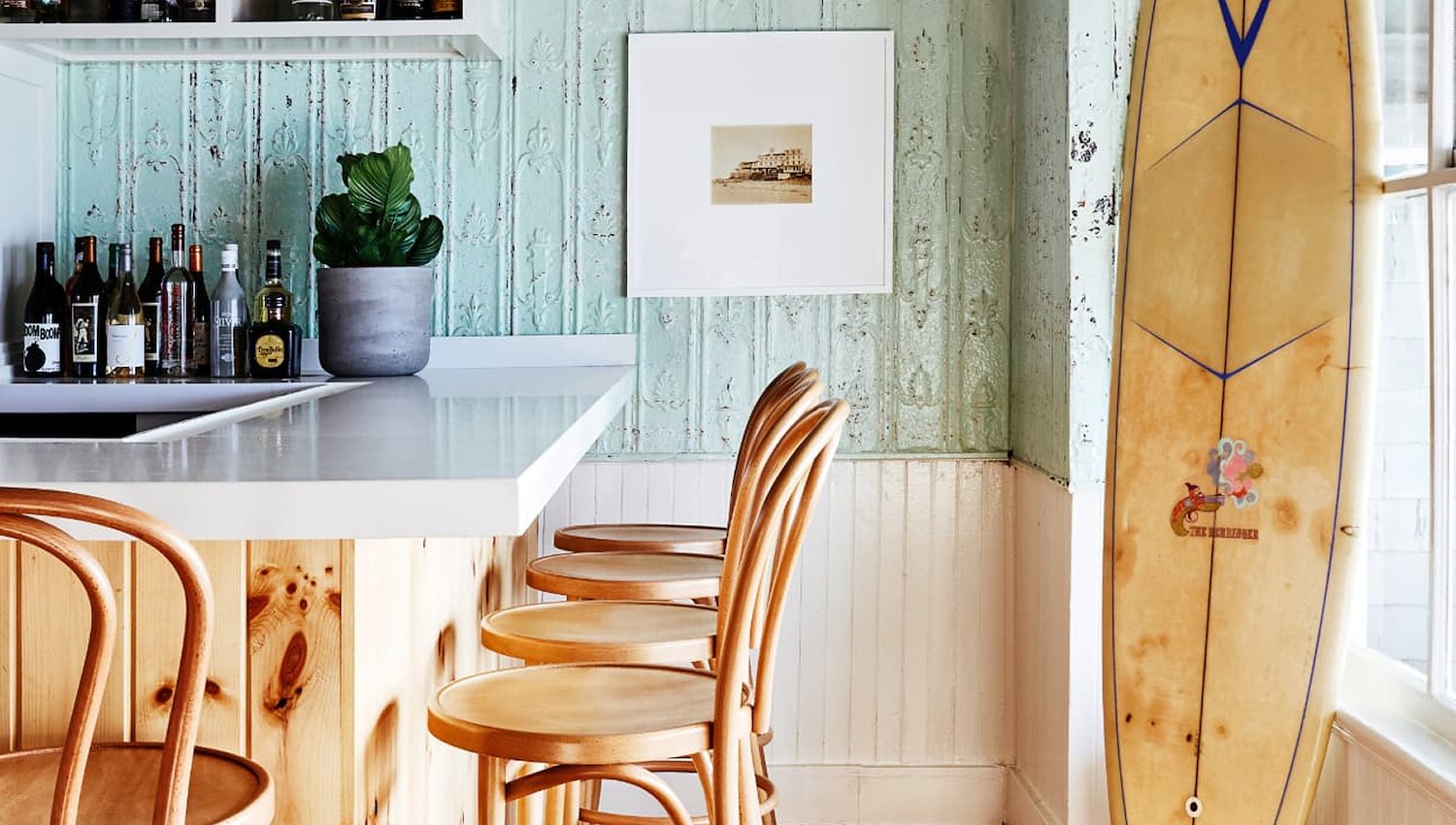 Vibrant surfboard is propped on a bar, enhancing the laid-back atmosphere of the room