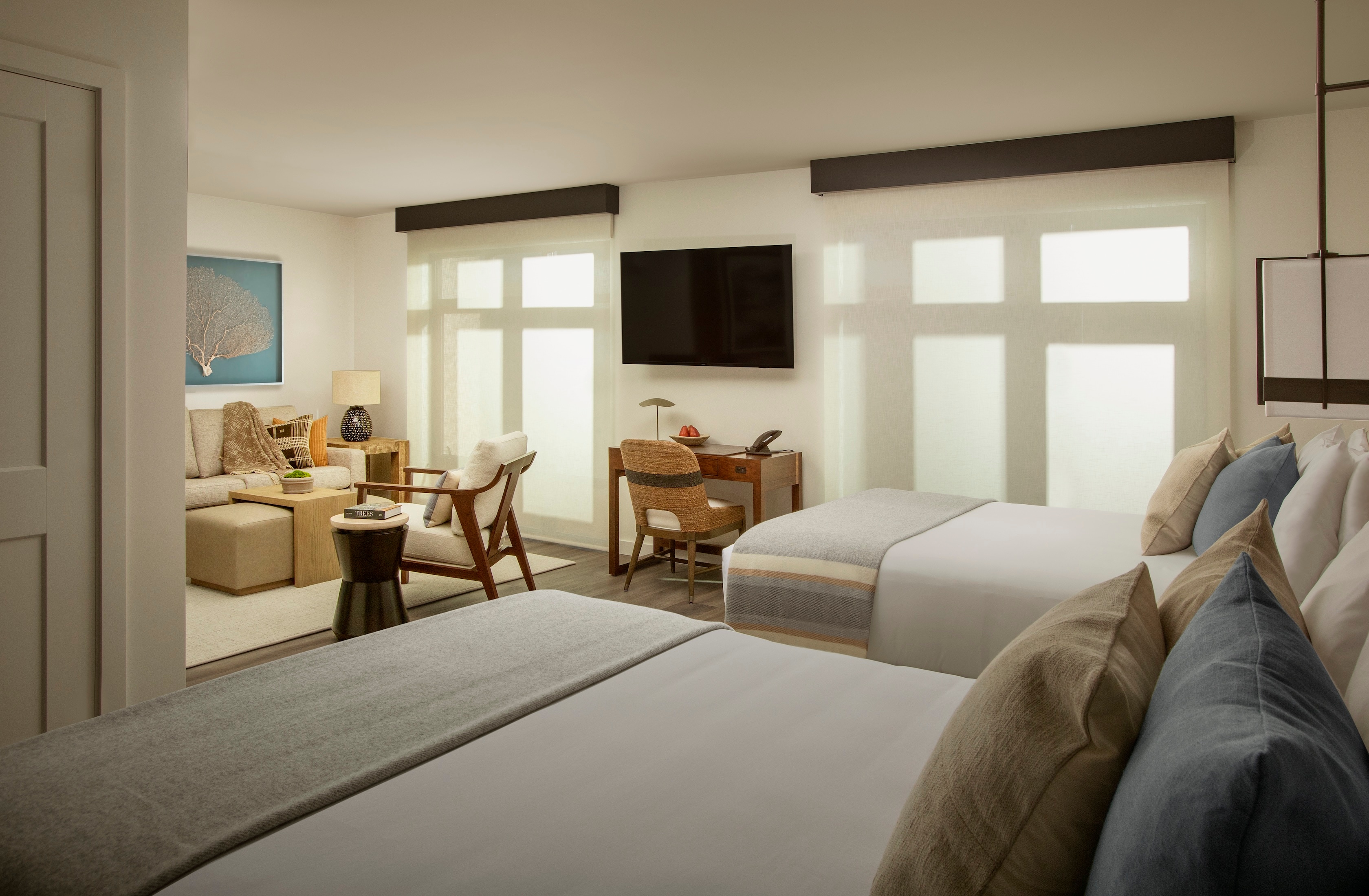 A wide view of a hotel room with a sitting area and a bedroom