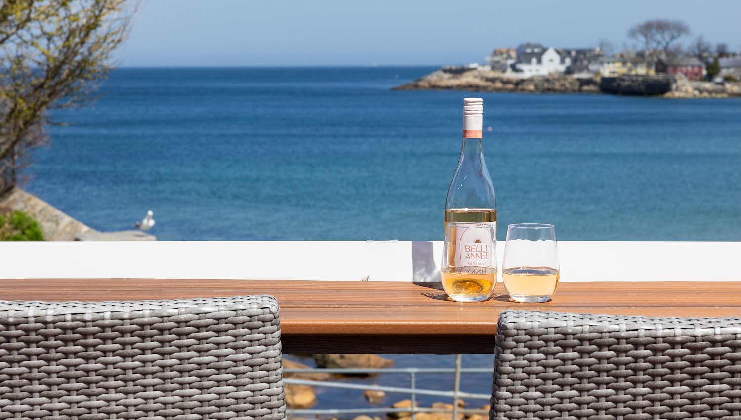 Beachfront deck with bar seating overlooking sandy shore and ocean in Rockport, MA