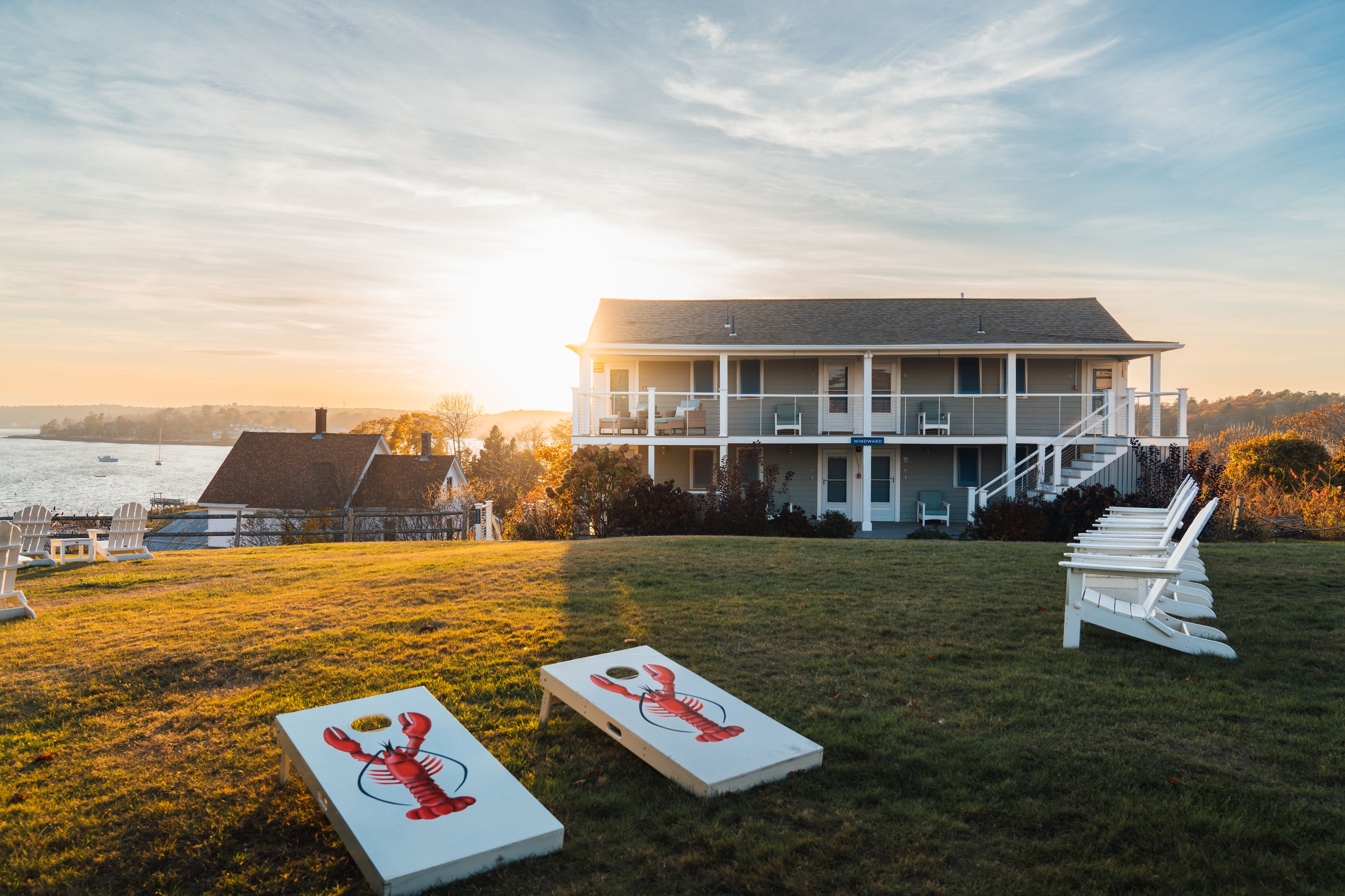 A lawn with chairs and a lobster bag toss game