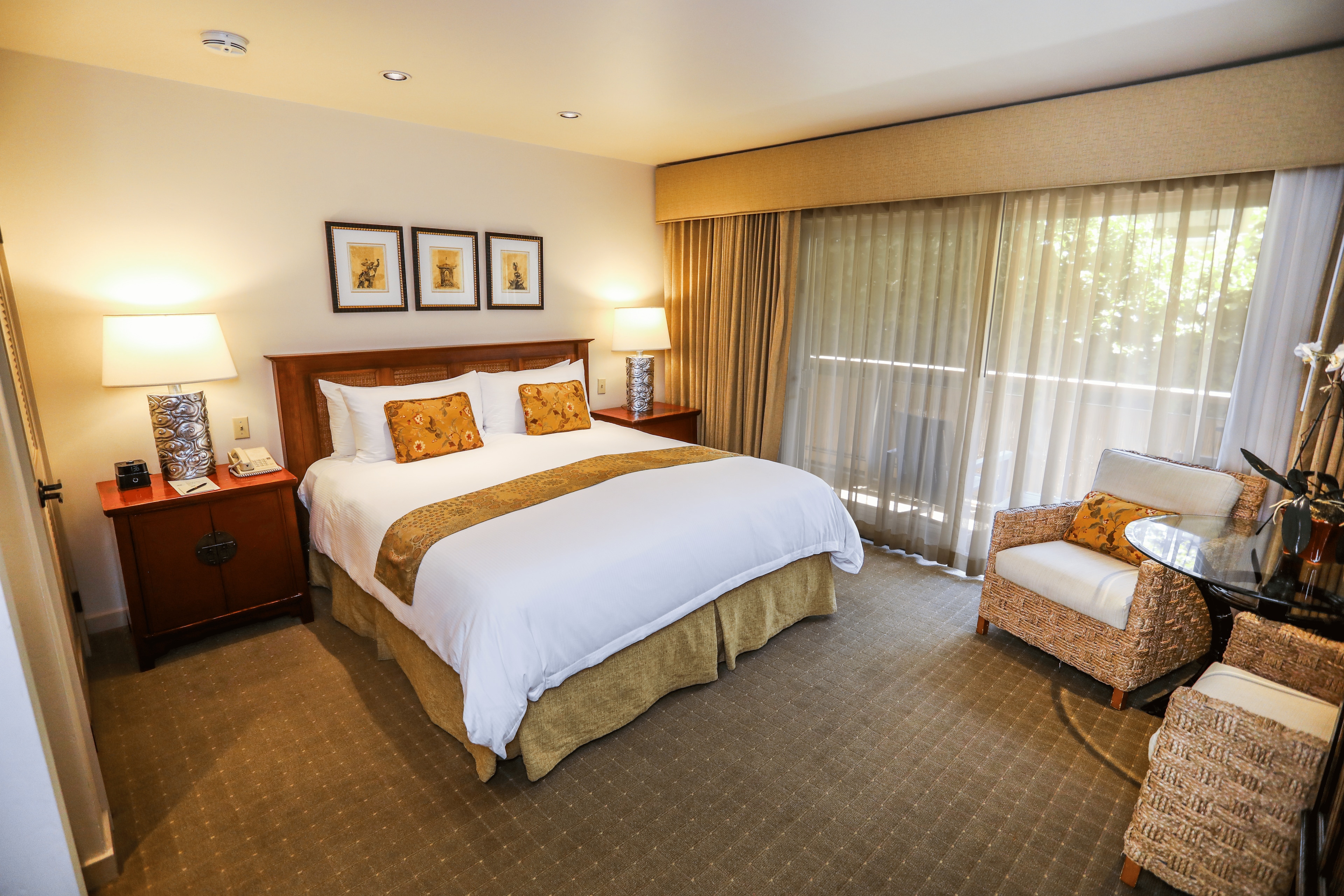 A hotel room with a bed, nightstand, chair, and window