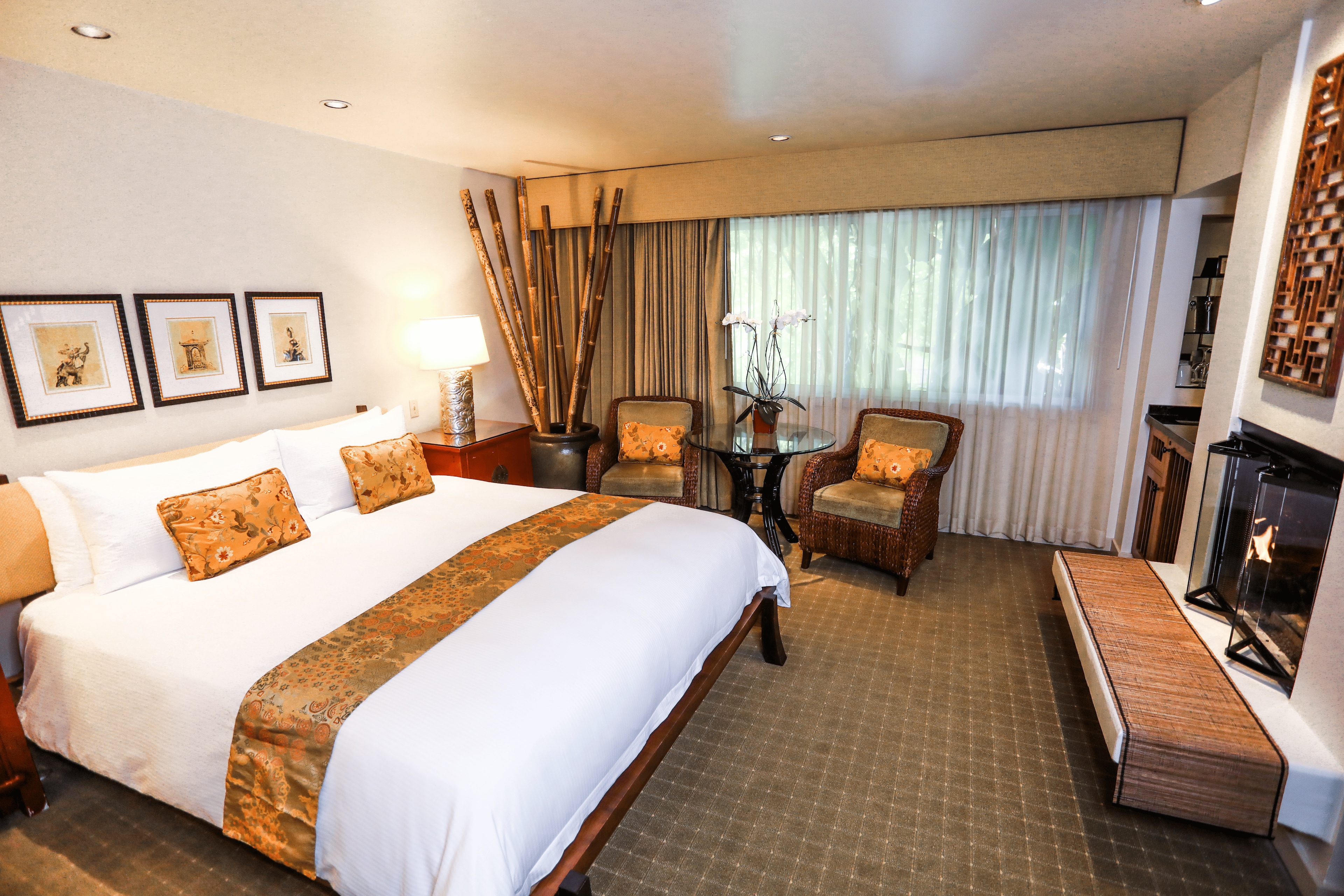 A hotel room with a large bed, seating area, and fireplace.