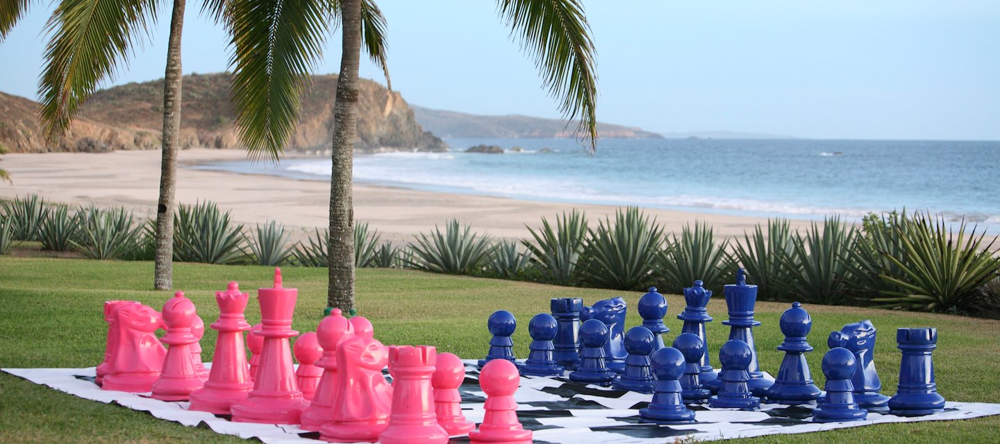 Jugando ajedrez en el césped a lo largo de la playa en el Resort Las Alamandas, Costalegre, Jalisco