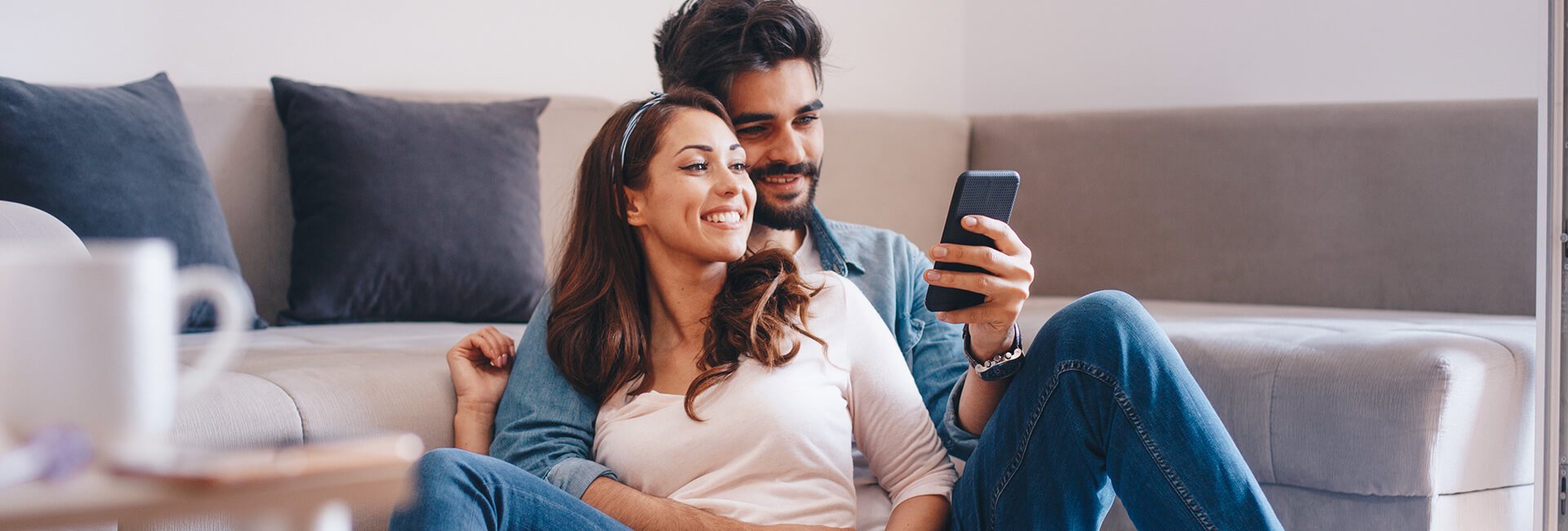 Smiling couple relaxing on a sofa and looking offers
