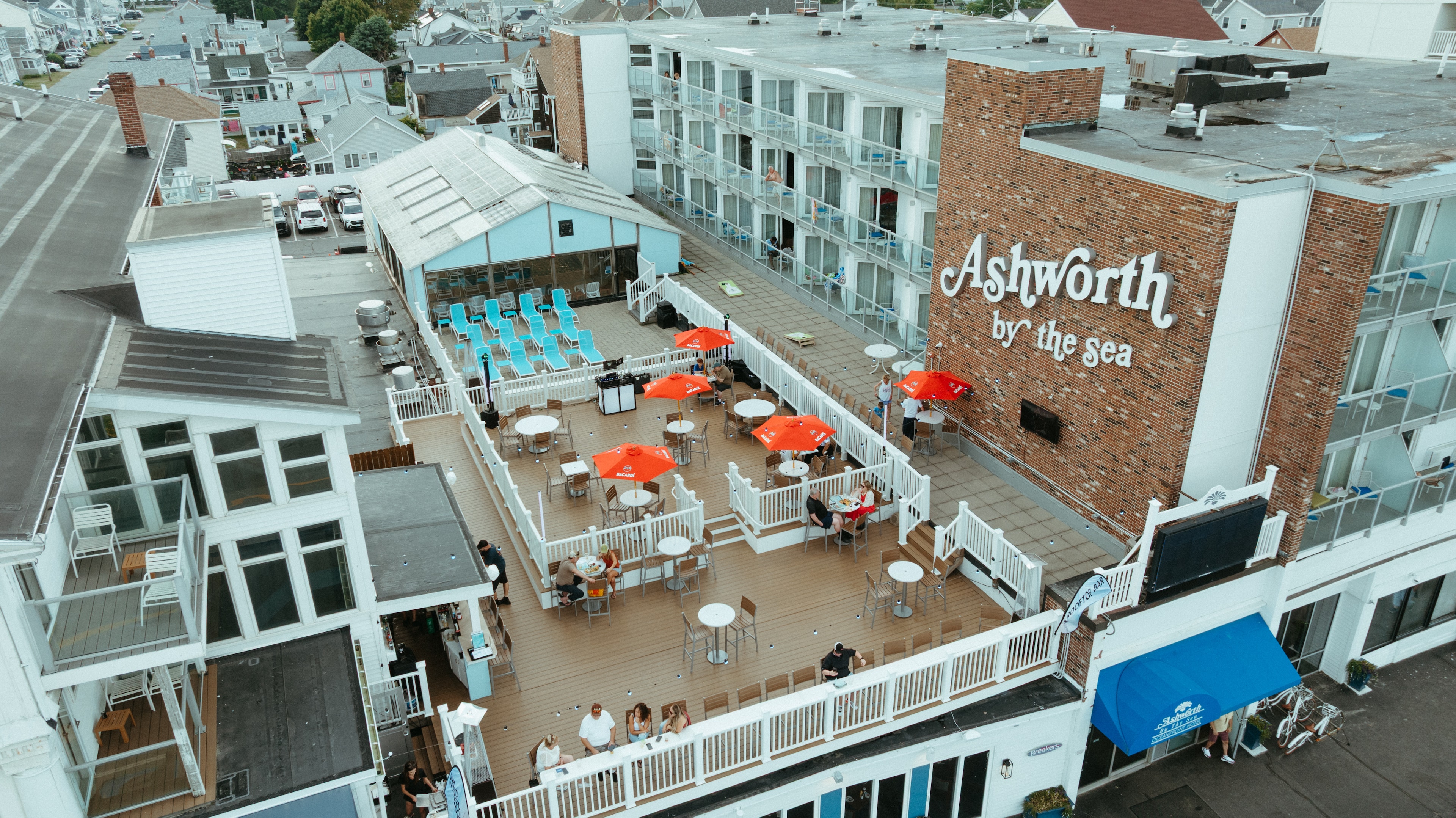 Aerial view of a hotel's rooftop patio with seating areas and umbrellas.