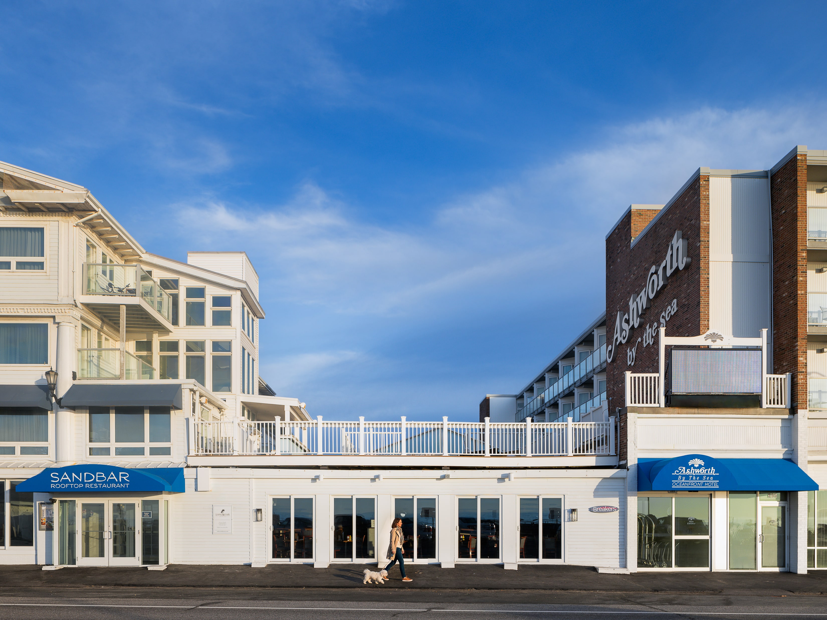 The exterior of Ashworth by the Sea hotel with a person walking a dog
