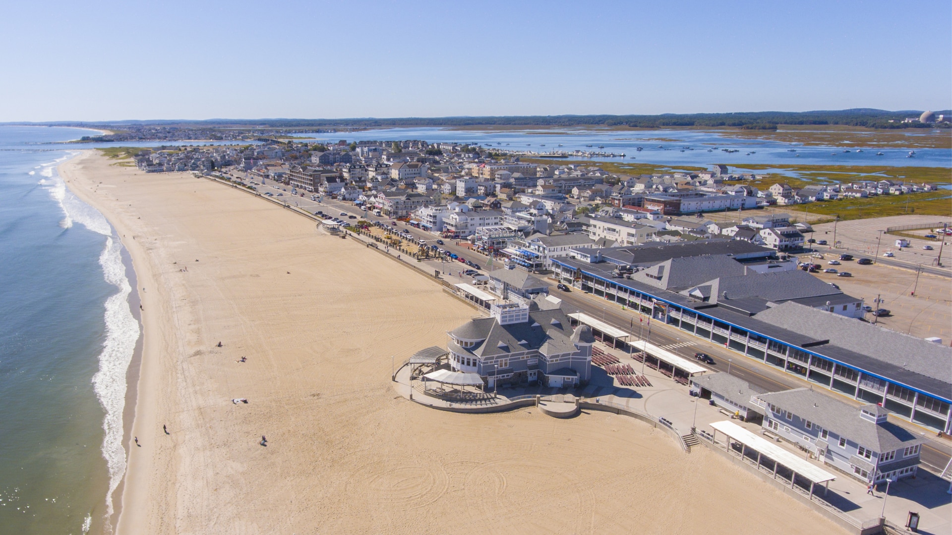 An aerial view of a beach with buildings and a body of water.