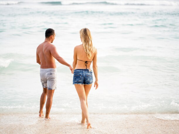 A young couple walking on the beach on Tybee Island