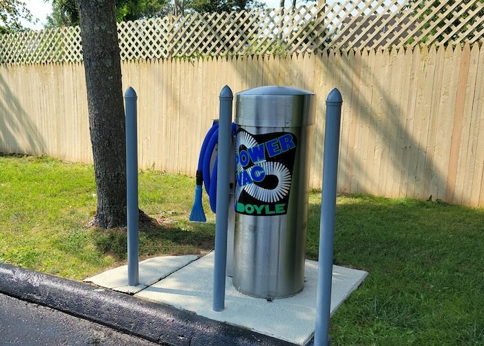 A parking meter with a blue sign on it at California Apartments in Absecon, New Jersey