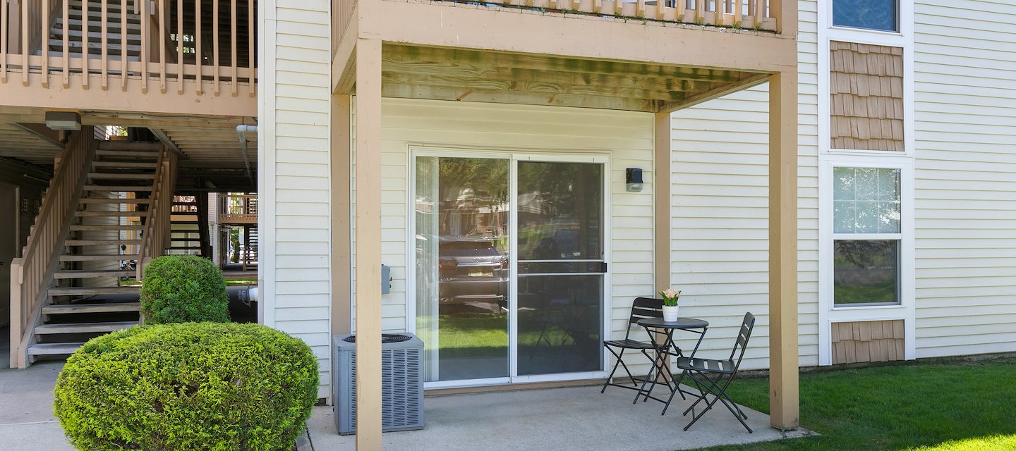 An apartment building with a balcony and patio area at California Apartments in Absecon, New Jersey