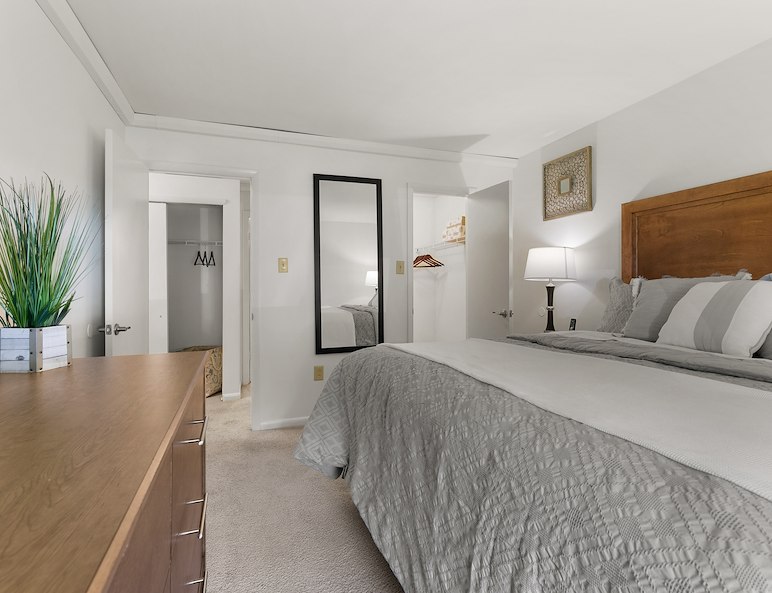 A furnished bedroom with dresser at California Apartments