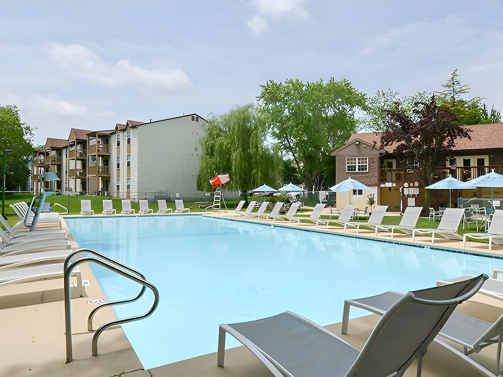 Seasonal swimming pool and wading pool at California Apartments, featuring spacious pool areas, comfortable lounge seating, and umbrellas. The pools are fully staffed with lifeguards for residents to enjoy a safe and relaxing summer experience.