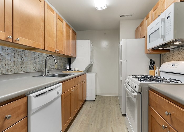 A kitchen with a stove, refrigerator, microwave and dishwasher at California Apartments in Absecon, New Jersey