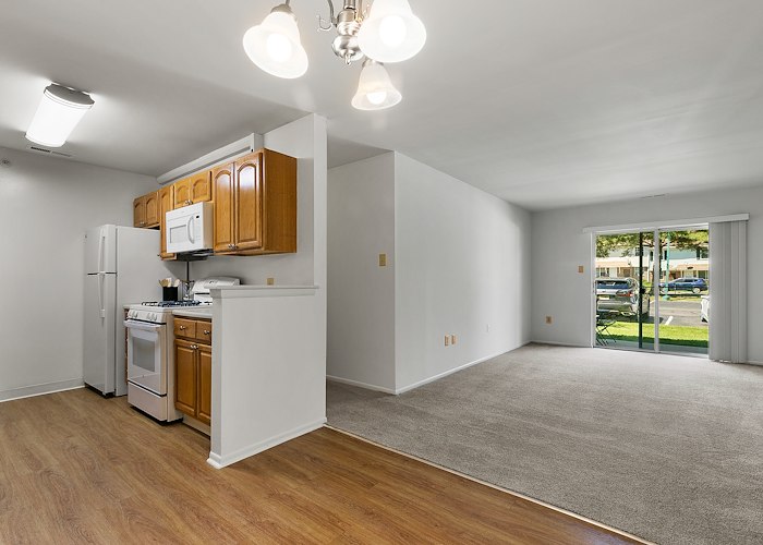 A kitchen with hardwood floors and a refrigerator at California Apartments in Absecon, New Jersey