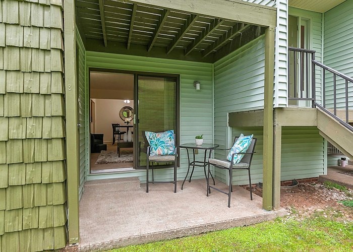 A patio with a table and chairs in front of a green house, Country Club Apartments, Huntington, West Virginia