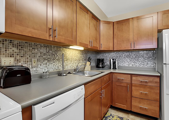 A kitchen with a refrigerator, stove, sink, and microwave at Gateway Apartments in Edwardsville, Pennsylvania
