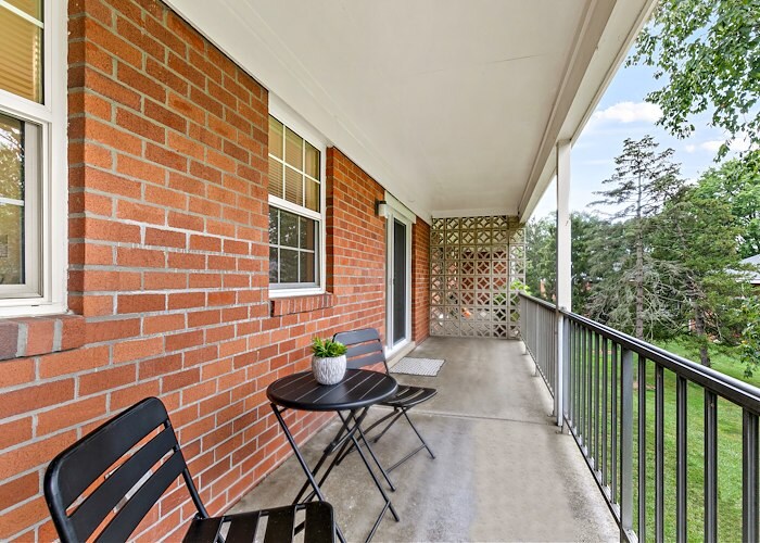 A balcony with chairs and a table on it at Gateway Apartments in Edwardsville, Pennsylvania