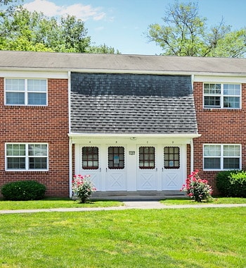 A brick home with a driveway and trees, Manor House Apartments, Lancaster, Pennsylvania