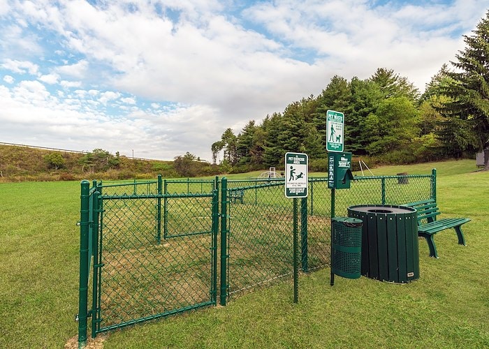 A green fence with a trash can and a bench, Pikeview Manor Apartments, Beckley, West Virginia