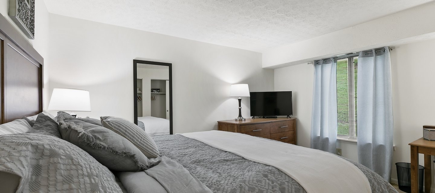 A bedroom with a bed, dresser and television, Pikeview Manor Apartments, Beckley, West Virginia