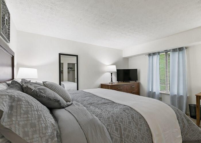 A bedroom with a bed, dresser and television, Pikeview Manor Apartments, Beckley, West Virginia