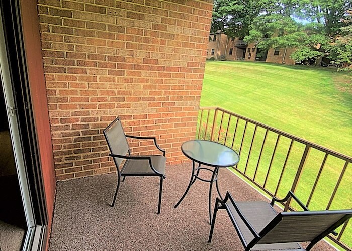 A balcony with chairs and table overlooking a green lawn, Powder Mill Apartments, York, Pennsylvania