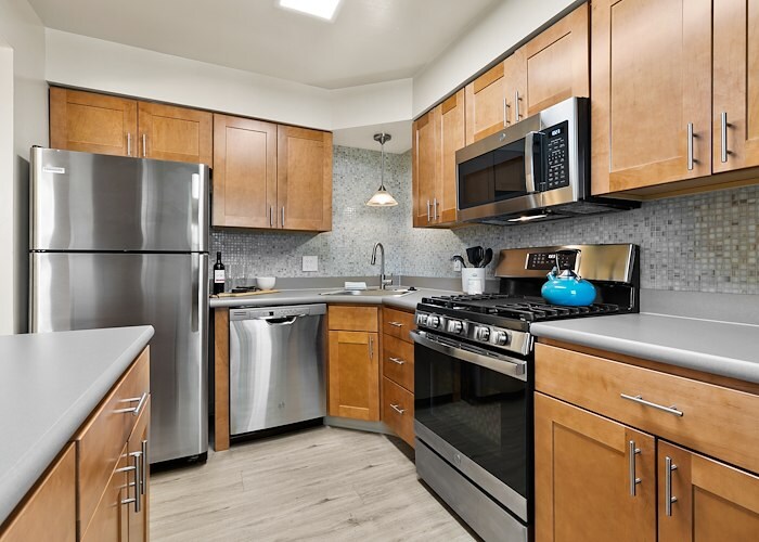 A kitchen with stainless steel appliances and wood cabinets, Powder Mill Apartments, York, Pennsylvania