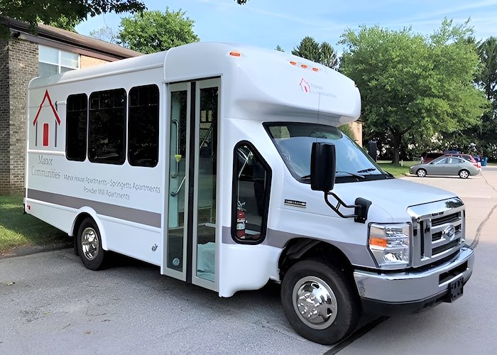 A white bus with a door open on the side, Powder Mill Apartments, York, Pennsylvania