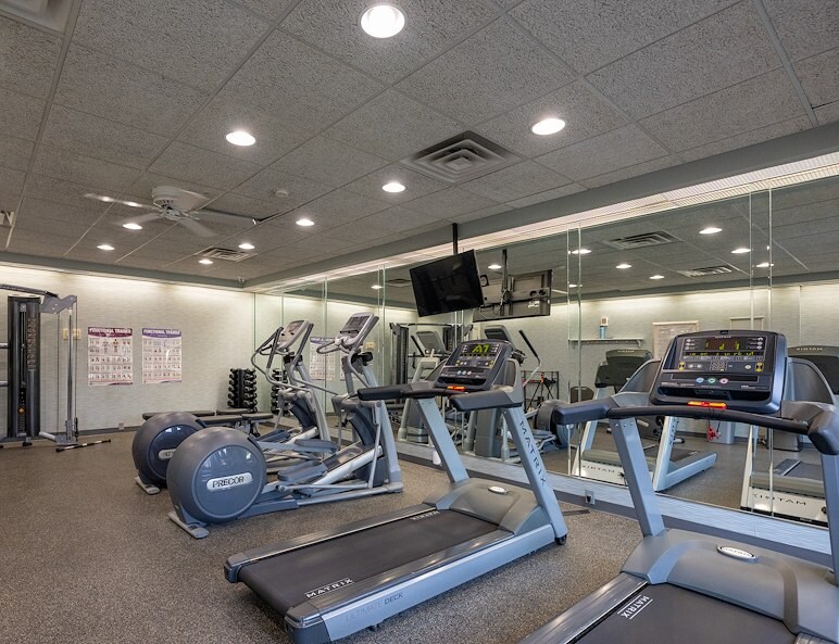 A gym room with exercise equipment and a television, Roxalana Apartments, Dunbar, West Virginia