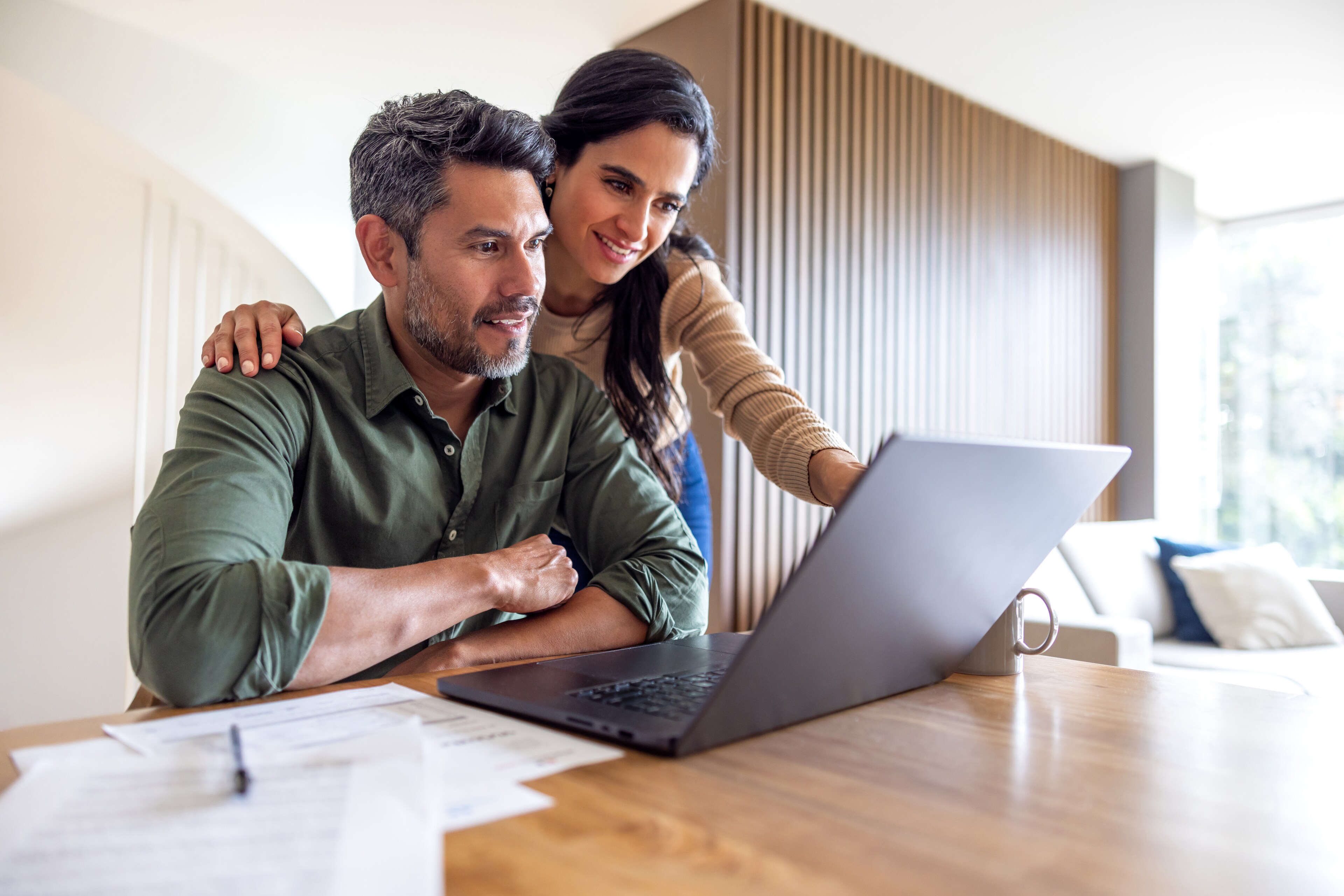 A couple reviews real estate options with Manor Communities on a laptop.