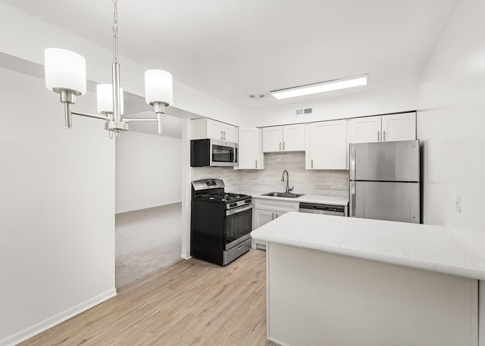 A kitchen with white cabinets and stainless steel appliances at Springetts Apartments in York, Pennsylvania
