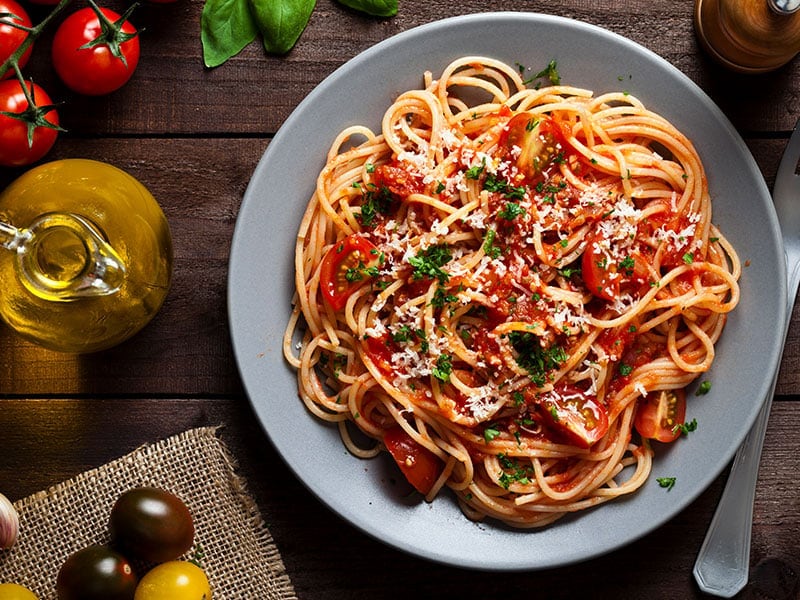 a plate of spaghetti with tomato sauce and parmesan cheese