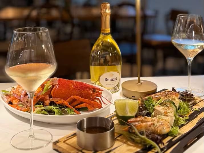 A fine dining setting with seafood and wine