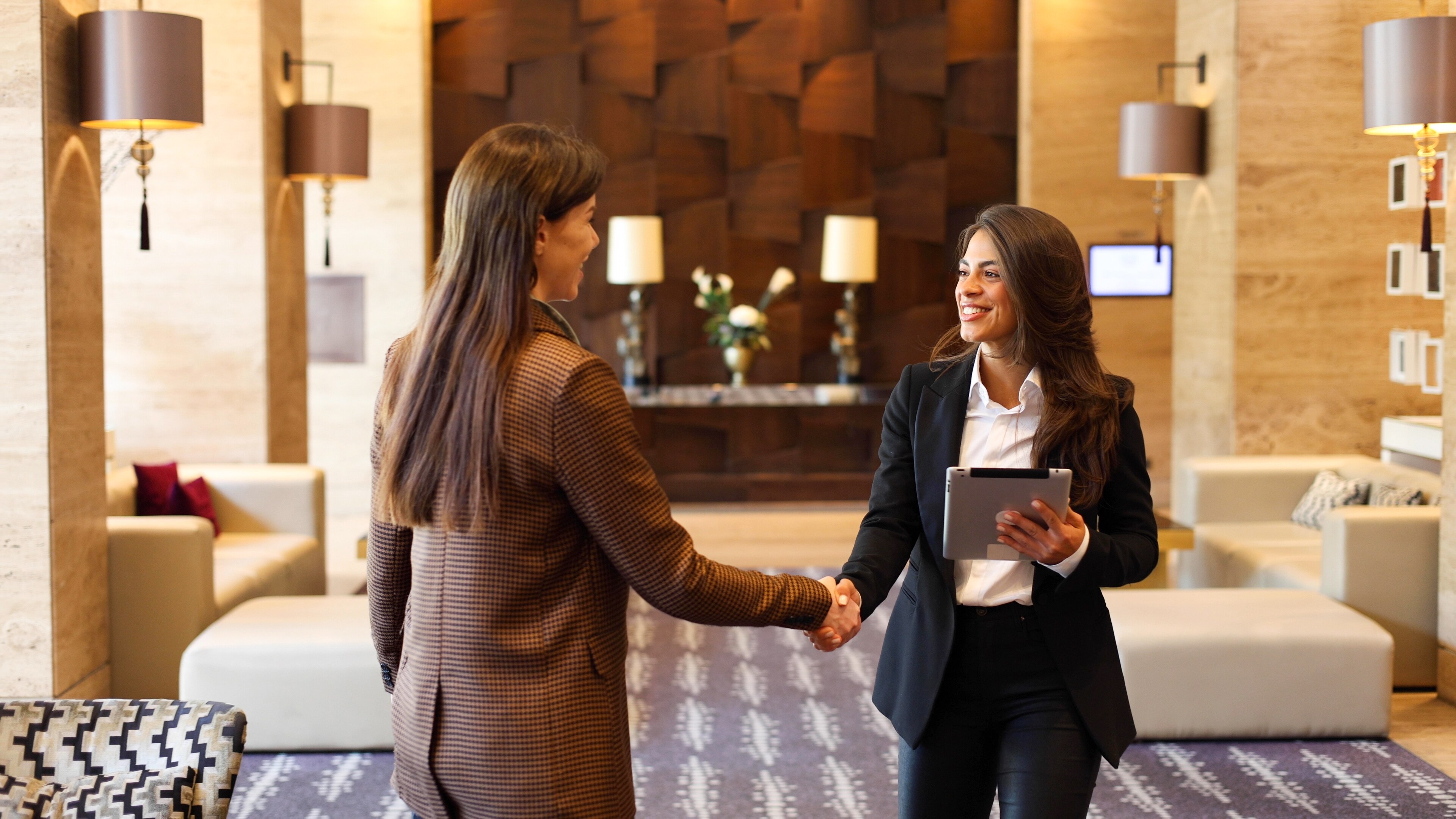 Two beautiful businesswomen meeting at the lobby of their company.