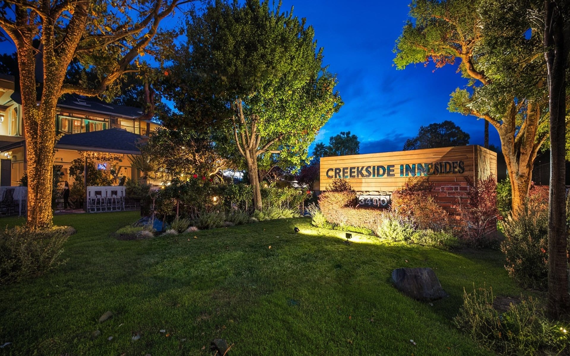 Creekside Inn is illuminated against a twilight sky in Palo Alto, California.