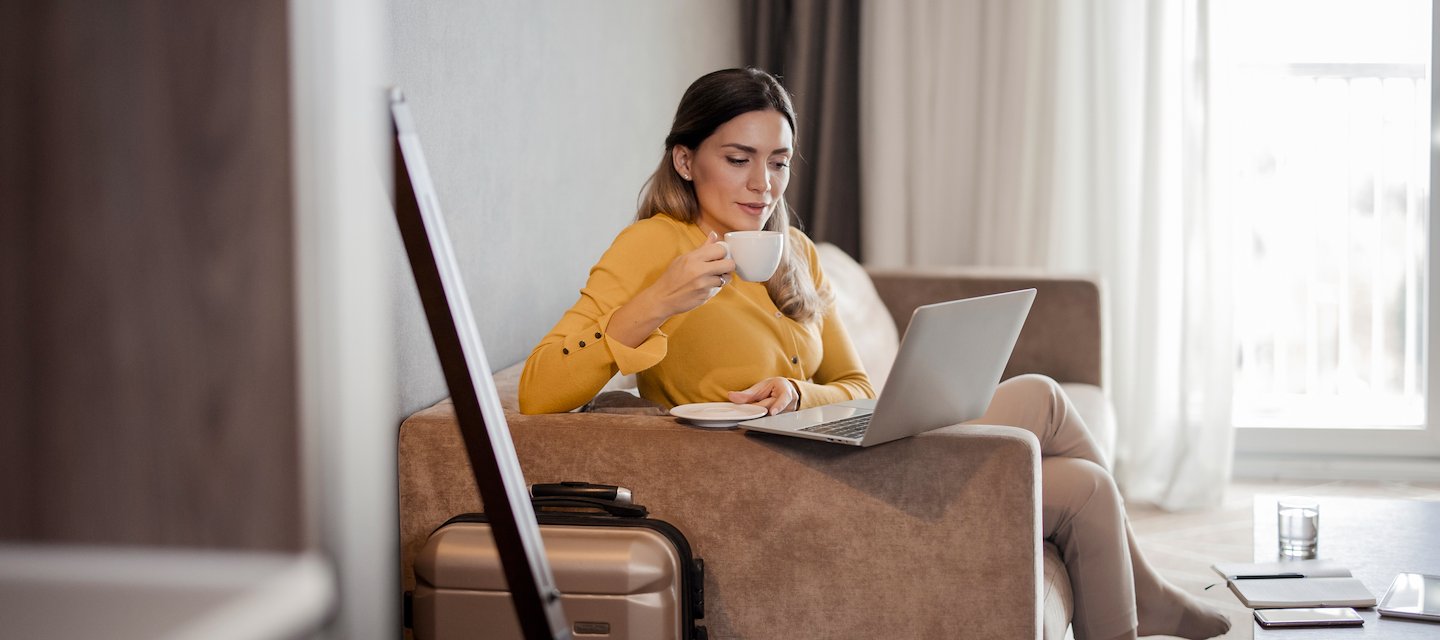 A guest enjoys coffee while working on a laptop at Creekside Inn.