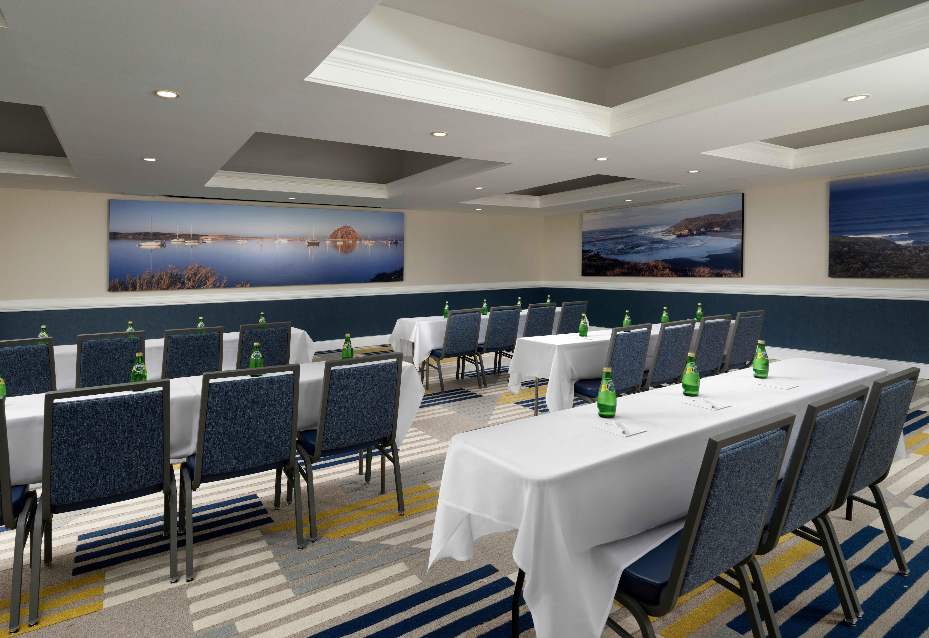 A meeting room with tables, chairs, and water bottles