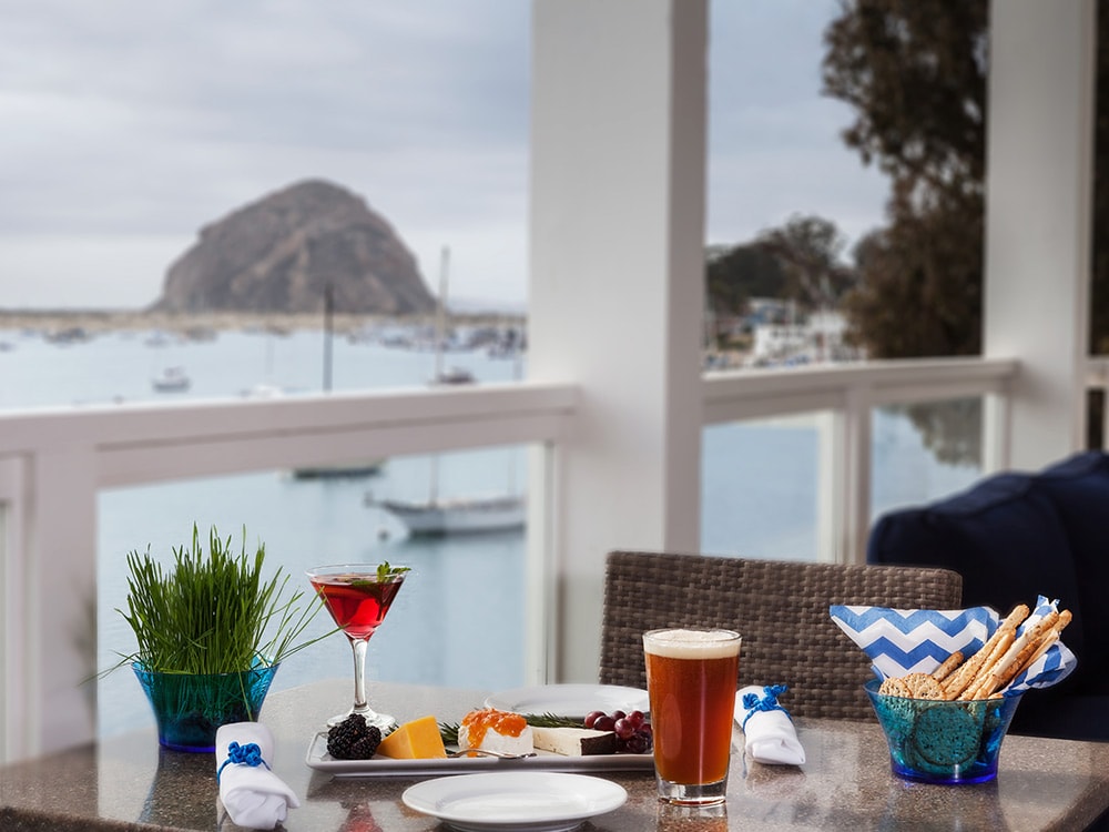 A table set for dining with a view of the ocean.