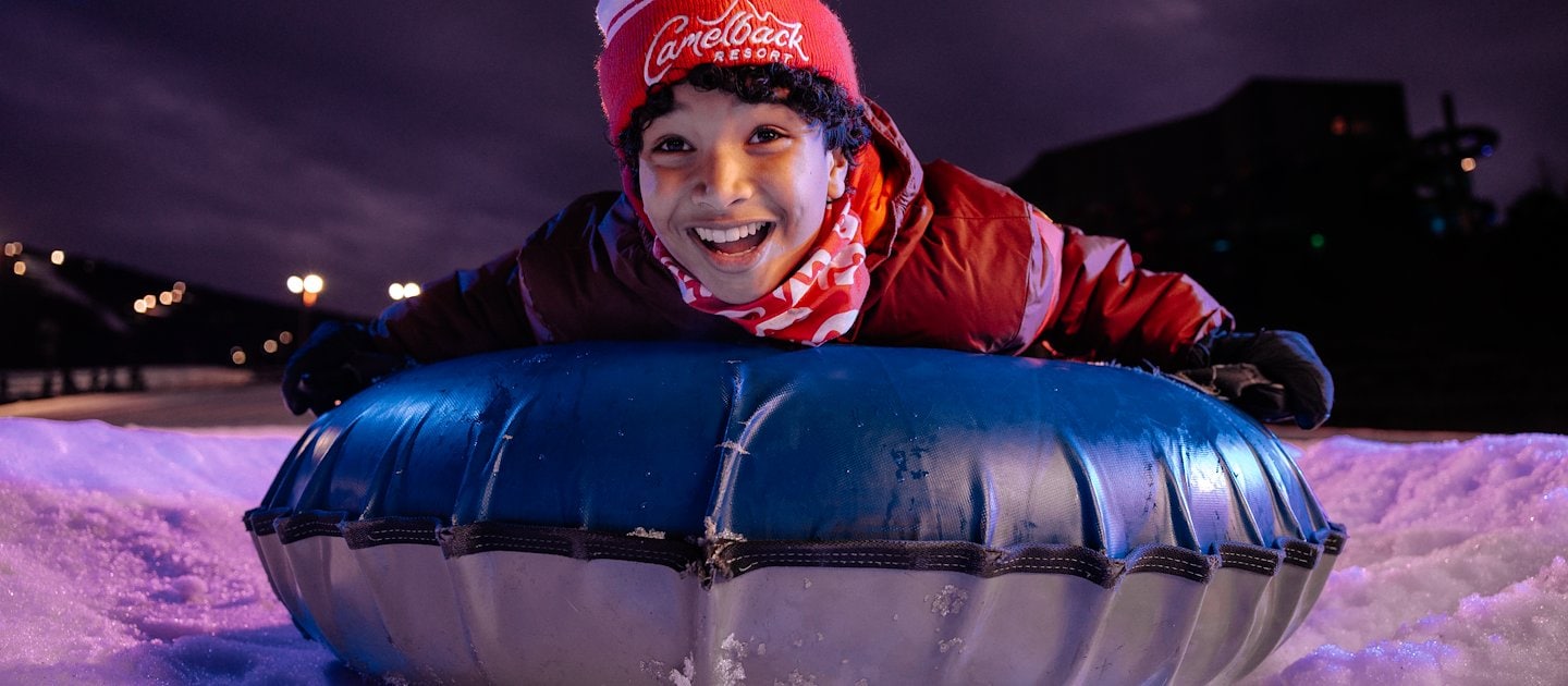Child sliding down the lanes at snow tubing – Camelback Resort