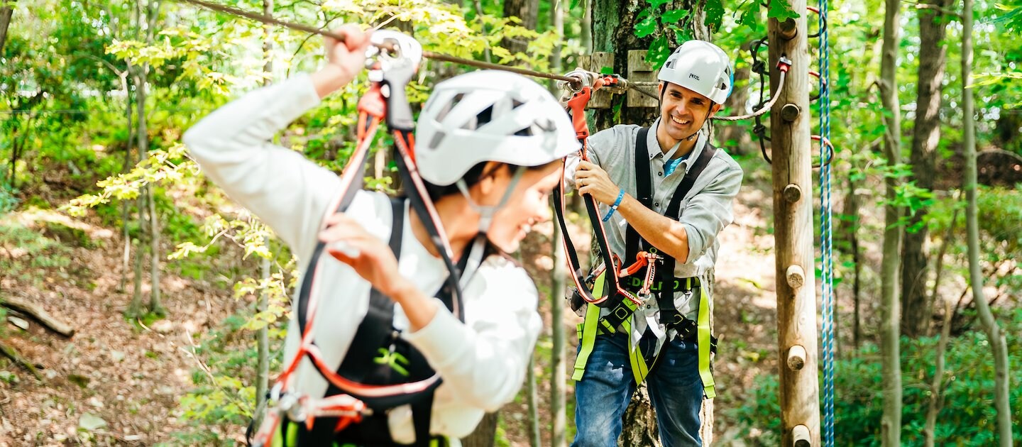 Adventurers navigate a treetop ropes course at Camelback Resort