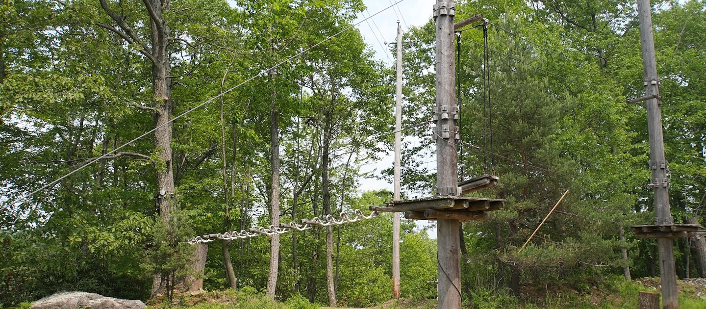 Adventurers navigate a treetop ropes course at Camelback Resort
