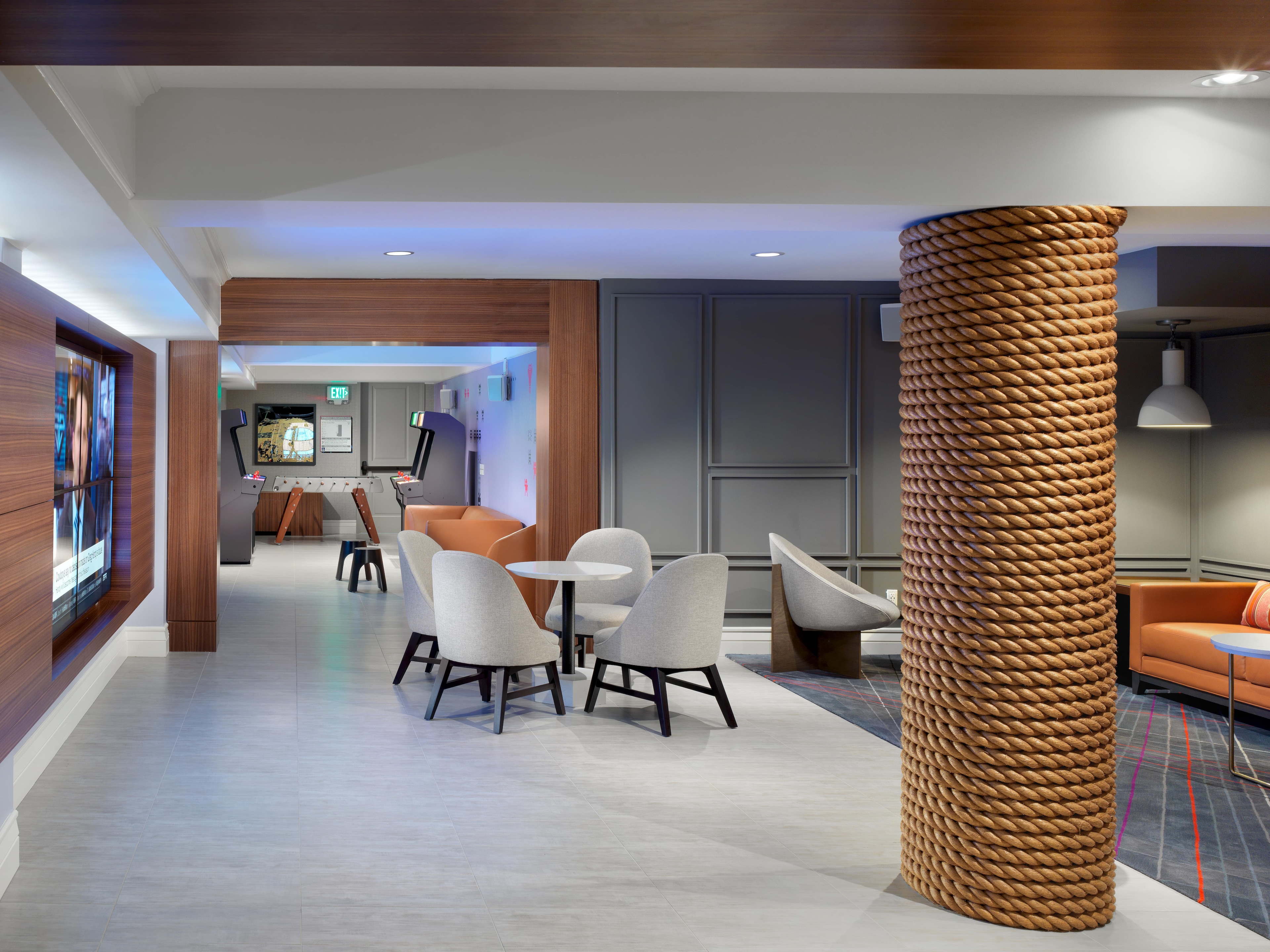 A modern hotel lobby with seating areas, games, and entertainment
