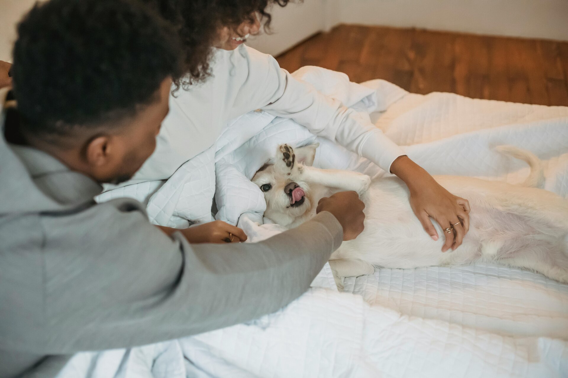 a woman and a dog lying on a bed