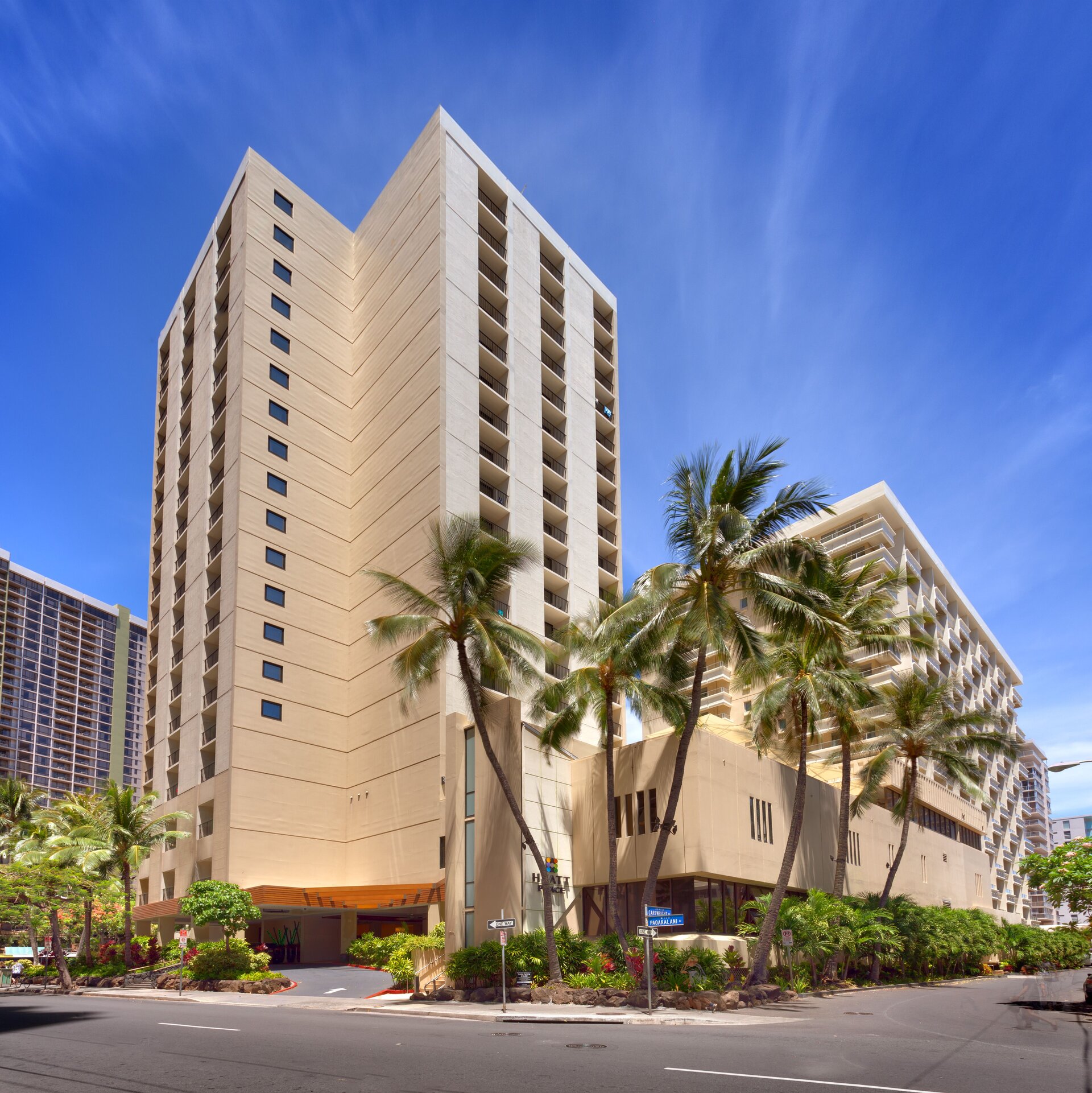 a tall building with palm trees and a street with Cathedral of Our Lady of the Angels in the background