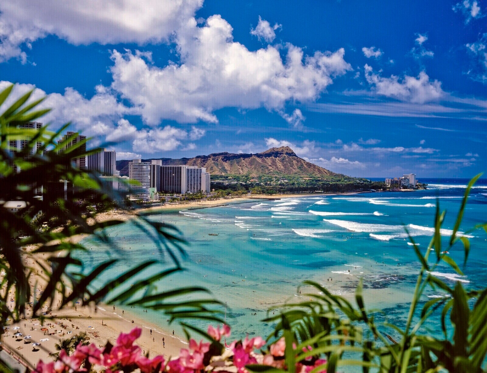 a beach with buildings and a mountain in the background
