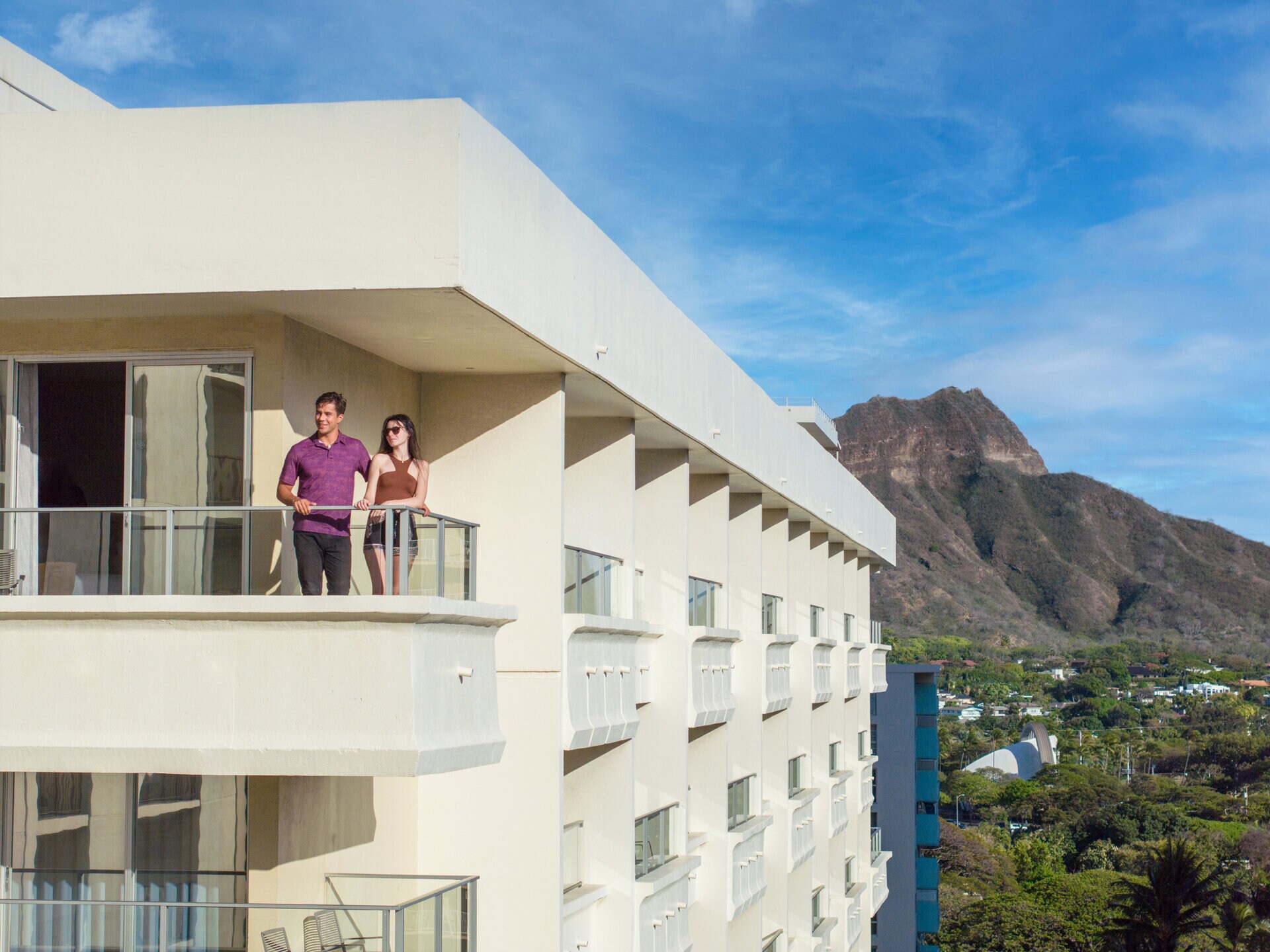 a man and woman standing on a balcony at our Waikiki hotel