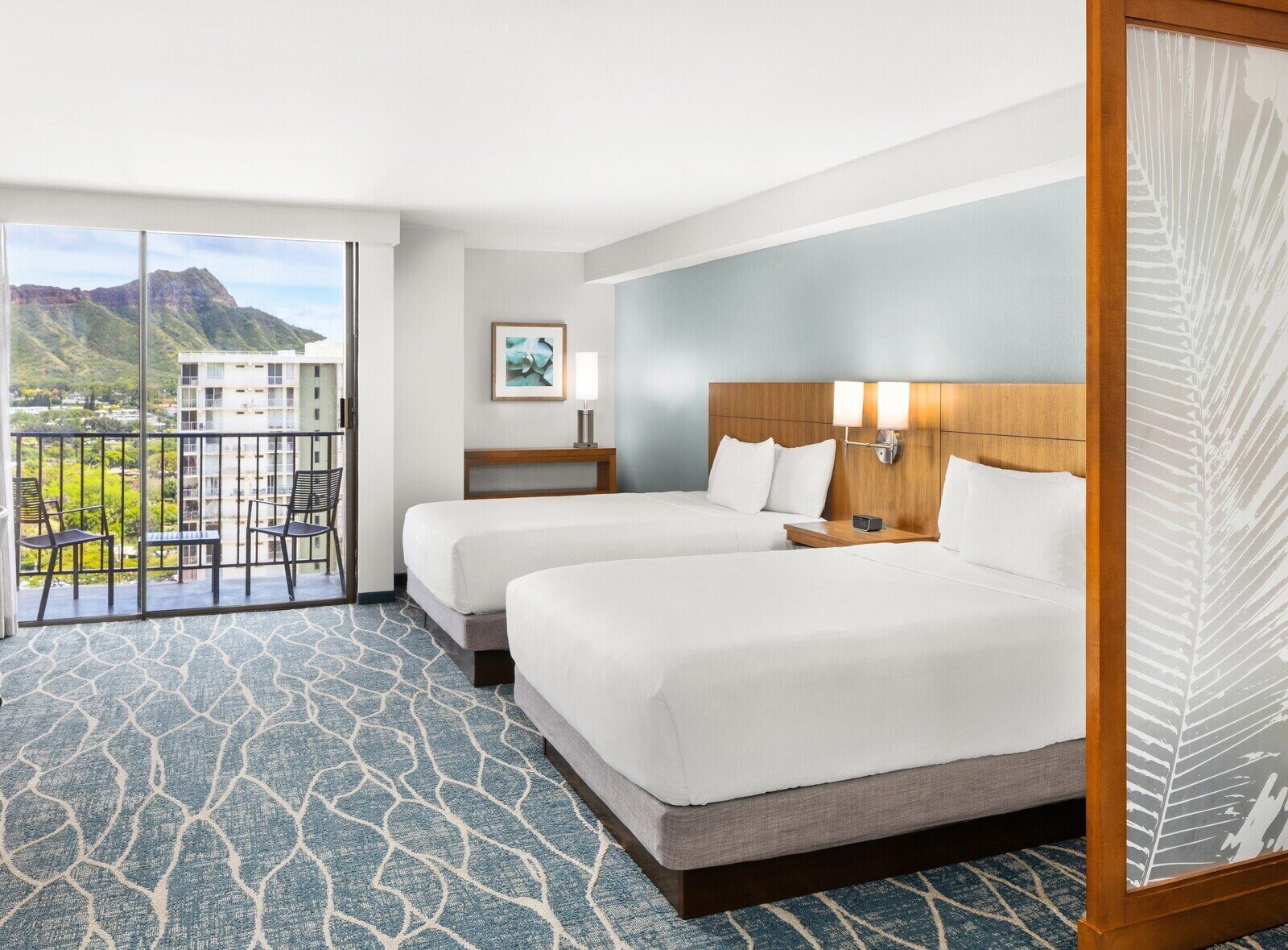 a room with two beds and a balcony